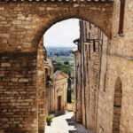 Picturesque narrow street in Spello ,Italy ,in the background church of Santa Maria del Prato